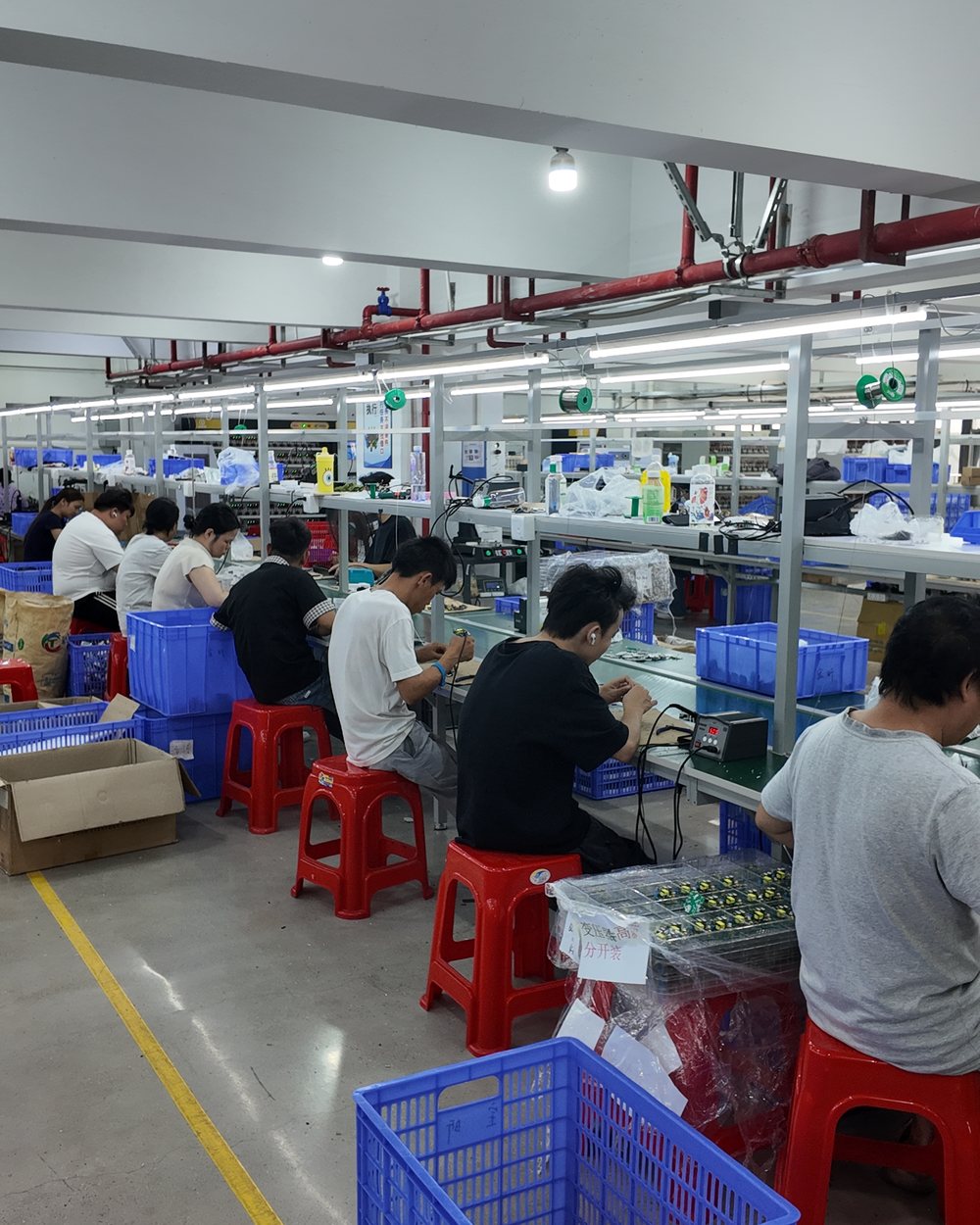 Operators at assembly benches in the workshop